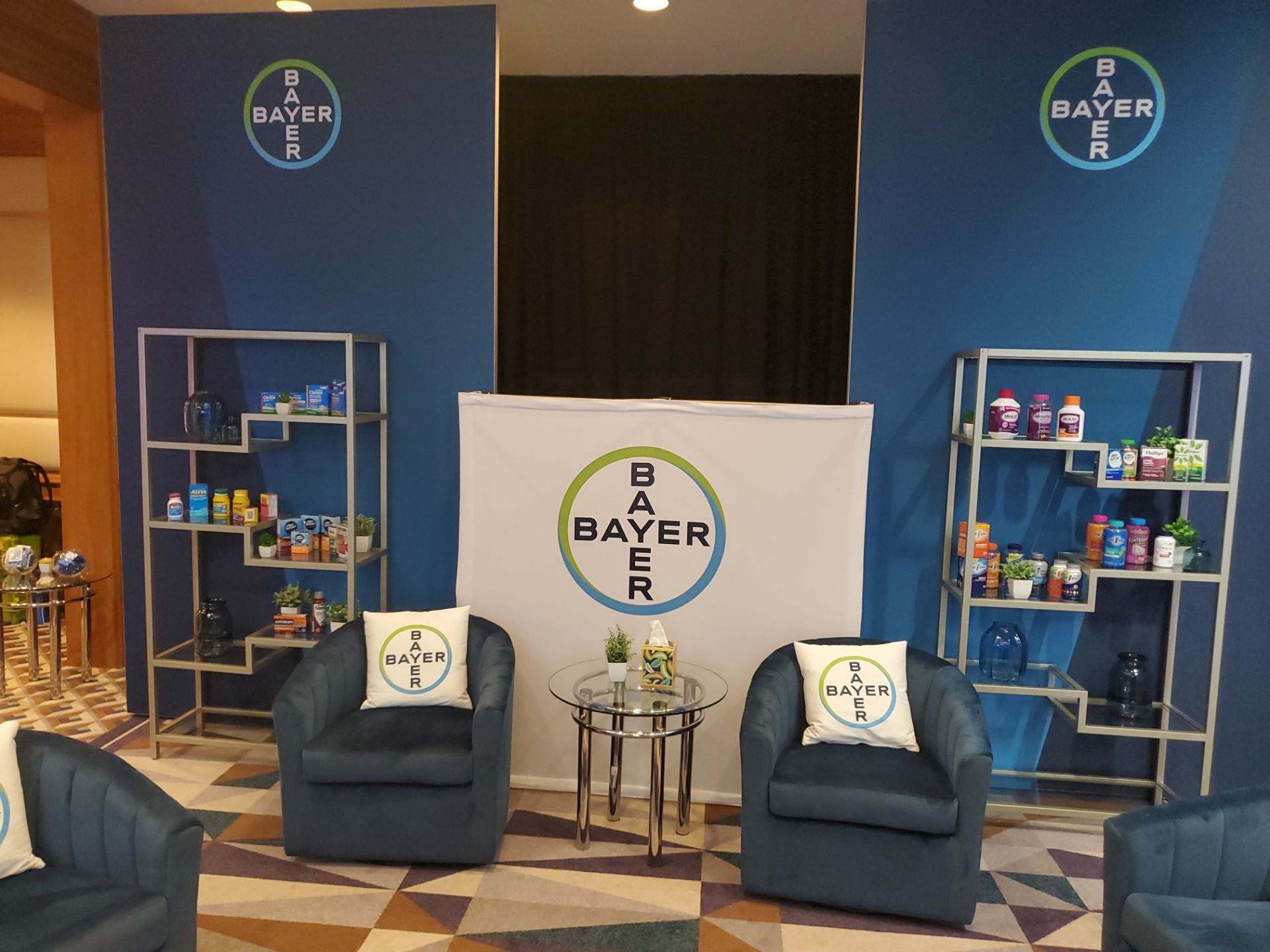 Annual Meeting suite — Bayer backdrop with branded chairs and product shelves