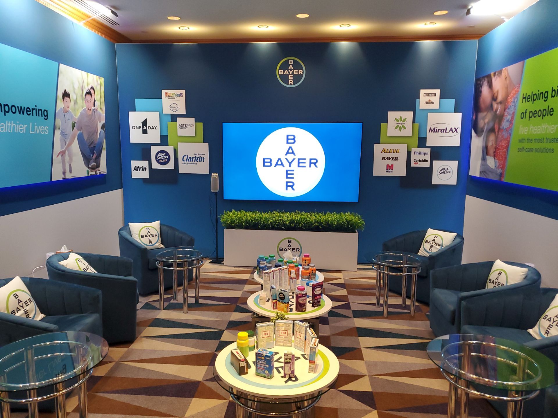 Annual Meeting suite — centered view with digital screen, brand logo wall, and product display table