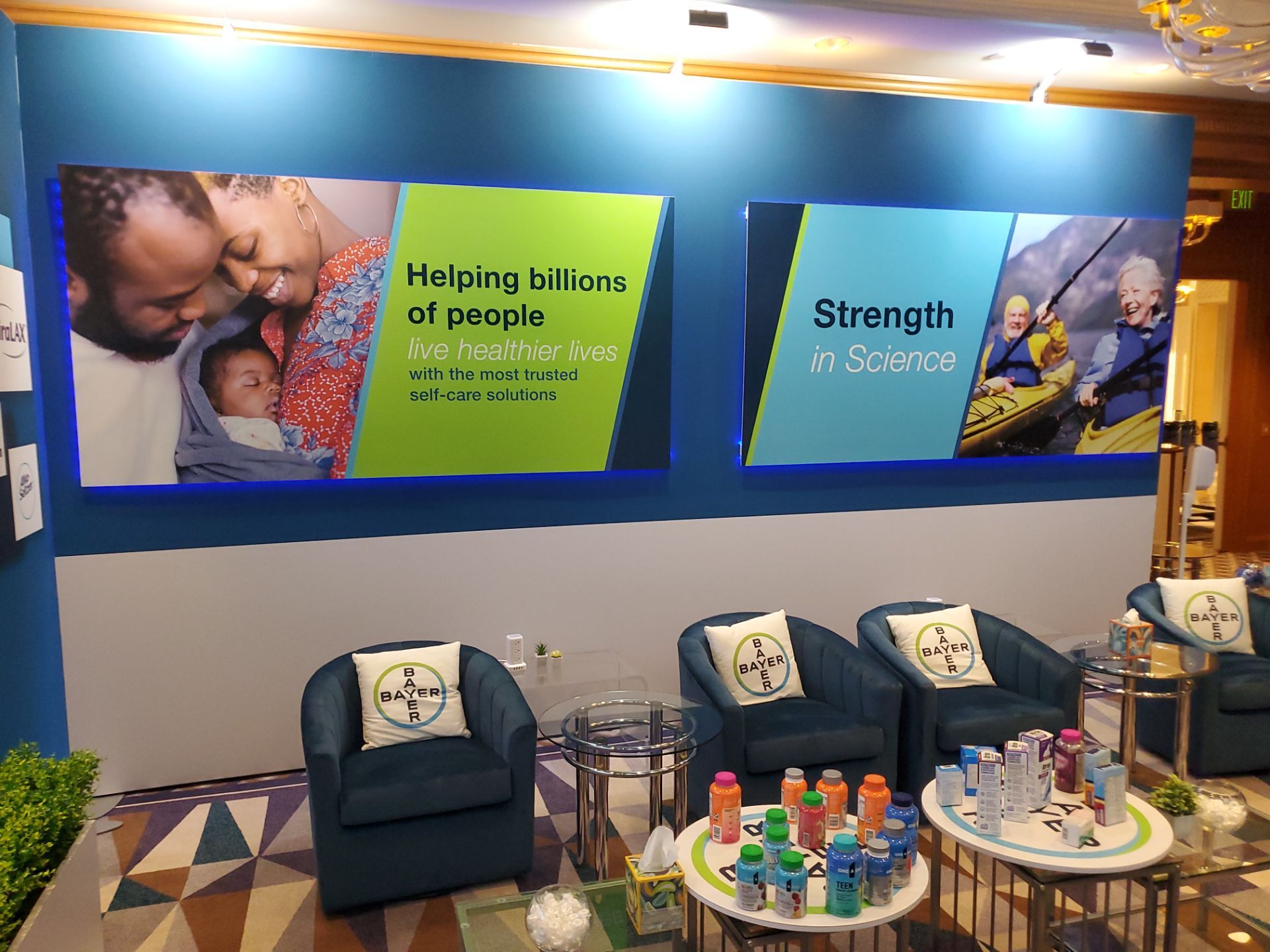 Annual Meeting suite — wall panels with 'Helping billions of people' and 'Strength in Science' messaging