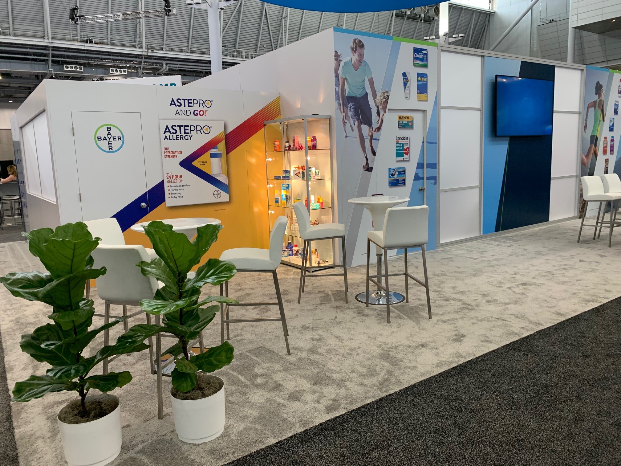 Completed Bayer booth — exterior approach showing materials, lighting, and graphics installed